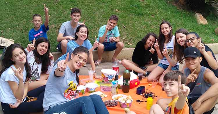 Os teens aproveitam o piquenique e na hora da foto, o gesto clássico da UPTIME: a nº 1!